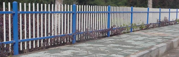White rod top fence panel with blue posts and rails are erected to protecting plants at the road side