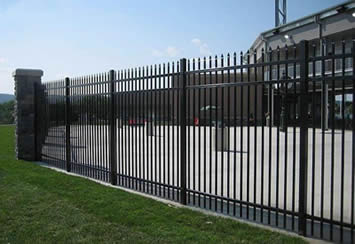 Black steel picket fencing panels are installed to safeguard a factory.