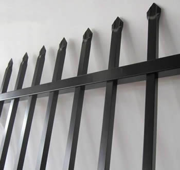  A black steel picket fencing panel are placed against the wall.